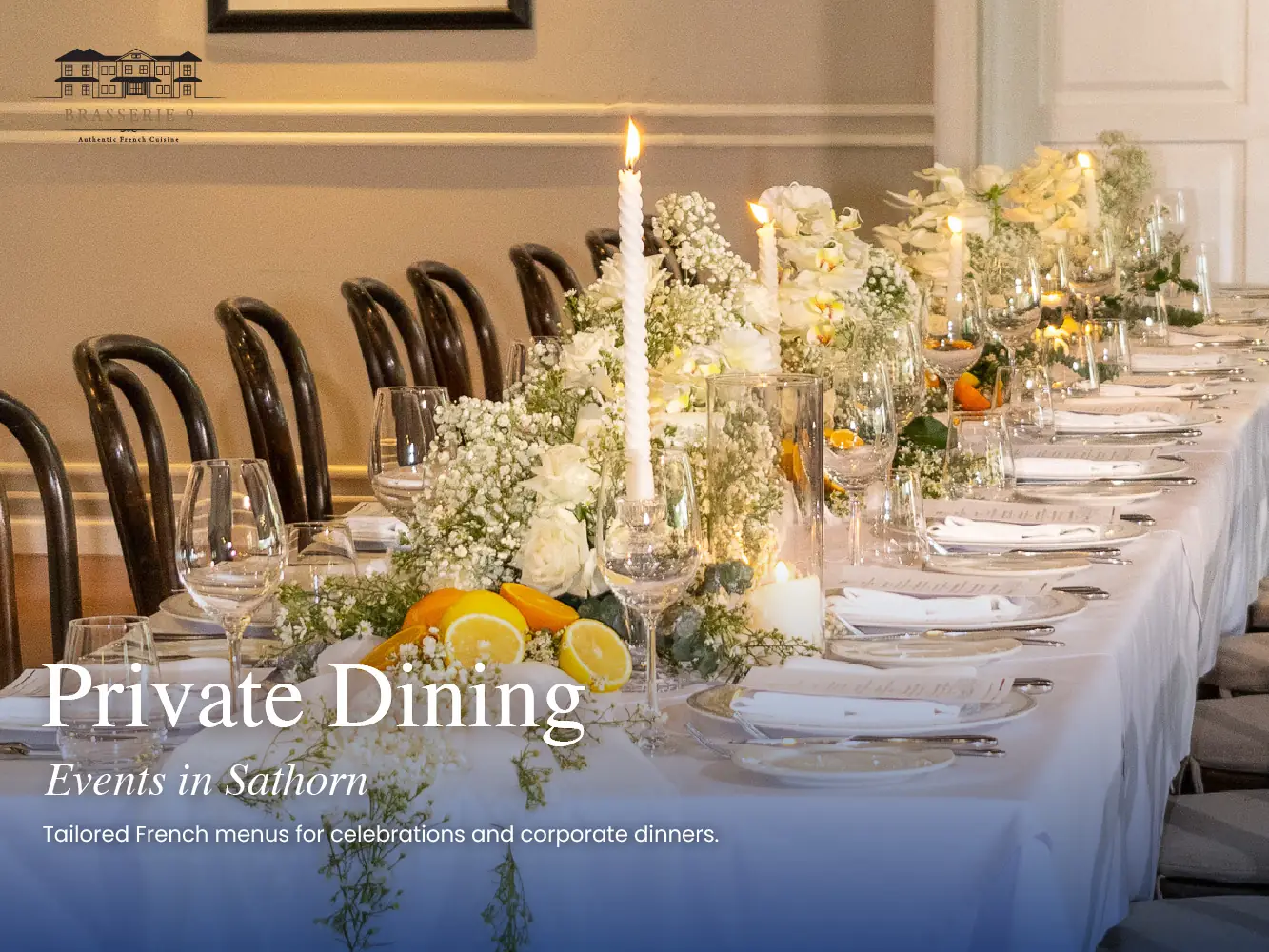 A long candle-lit table with white flowers set for a private dinner at Brasserie 9, a French restaurant in Sathorn, Bangkok